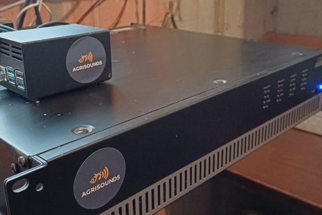 AgriSounds Raspberry Pi 5 and HiFiBerry DAC8x controller mounted next to a 100V-line amplifier in a pig barn's technical room